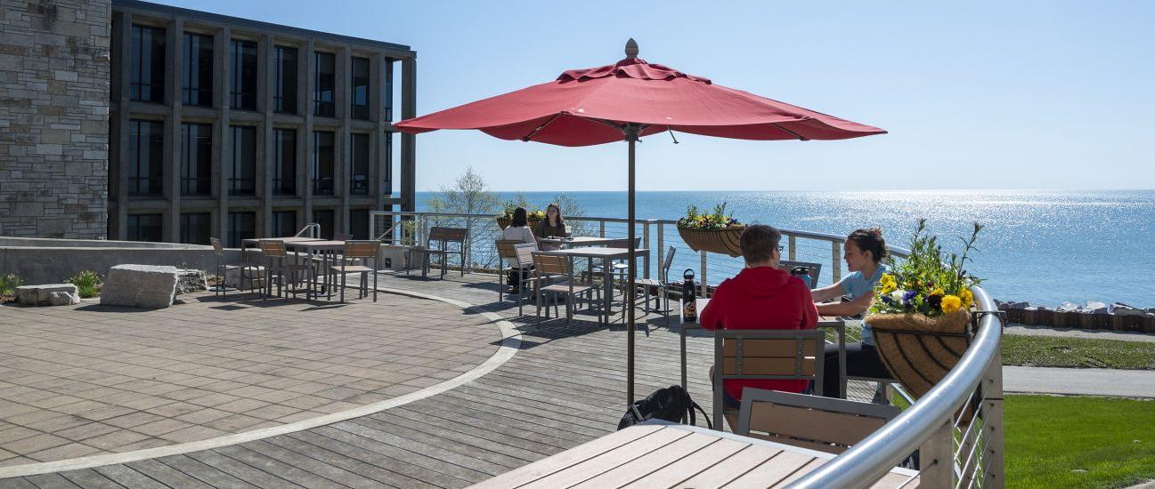 Students enjoy the nice weather and Lake Michigan view from the Straz patio.
